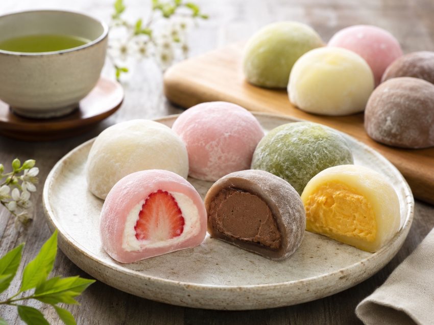 Mochi z różnymi nadzieniami — japoński deser z ciasta ryżowego Japoński deser mochi z różnymi nadzieniami na talerzu, kolorowe kulki ryżowe z truskawką, czekoladą i kremem